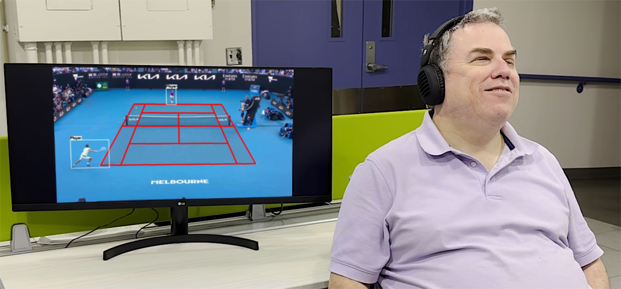 A visually impaired participant sitting on a chair with headphones on, listening to a tennis match via Front Row.